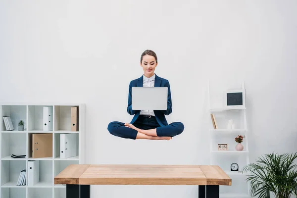 Gülümseyen Genç Kadını Ofiste Levitating Dizüstü Bilgisayar Kullanarak — Stok fotoğraf