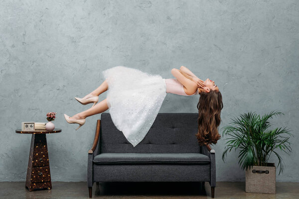 beautiful barefoot girl hovering above couch 