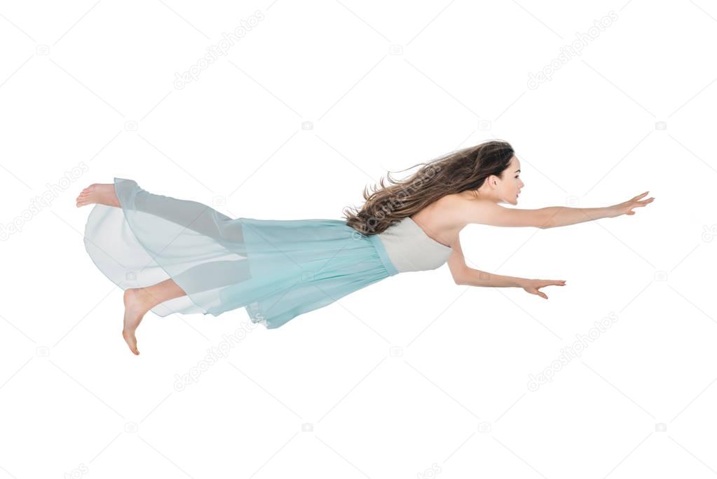 beautiful girl in dress levitating and looking away isolated on white 