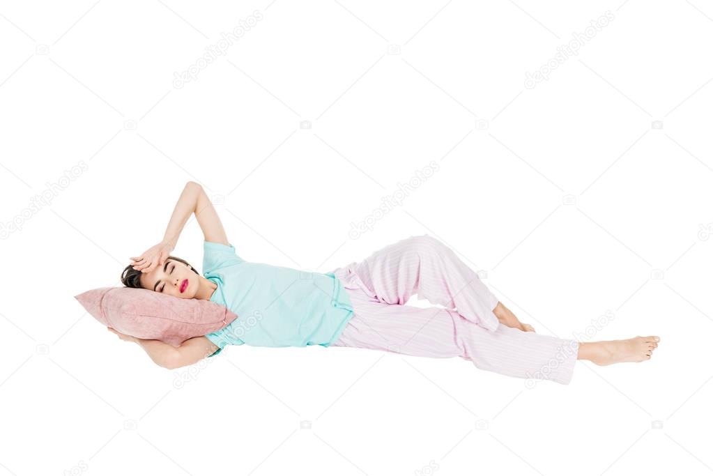 girl in pajamas lying on pillow with closed eyes isolated on white