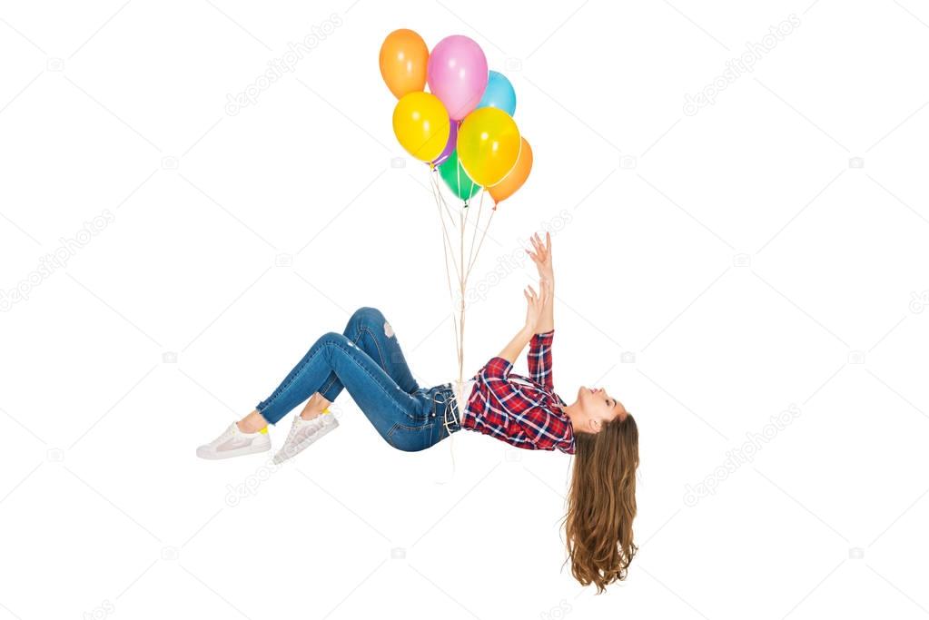 young woman levitating with colorful balloons isolated on white