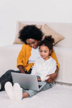Afrika kökenli Amerikalı anne ve sarılma ve laptop bir şey izlerken kız