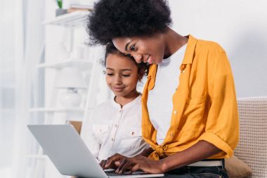 Afrika kökenli Amerikalı anne ve kızı evde laptop arıyorum