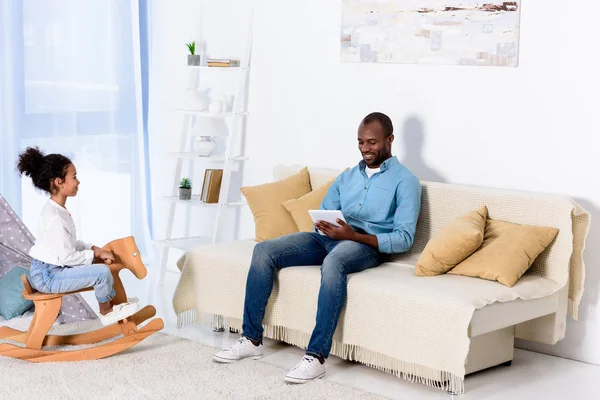 African American Father Tablet Daughter Sitting Rocking Horse — Stock Photo, Image