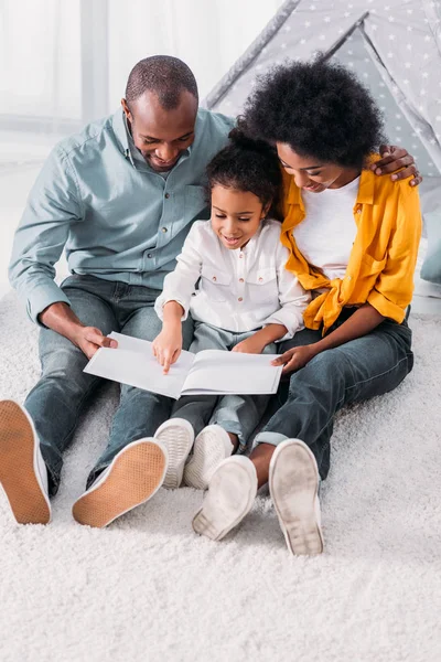 Африканская Американская Дочь Читает Родителей Полу Дома — стоковое фото