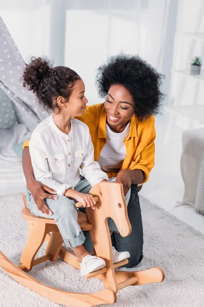 African American Mother Playing Daughter Rocking Horse Home — Stock Photo, Image