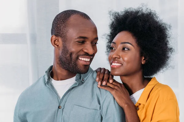 ハグと家庭でお互いを見て笑顔のアフリカ系アメリカ人カップル — ストック写真