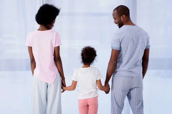 非洲裔美国人的父母和女儿的后方看法在家里牵手 — 图库照片