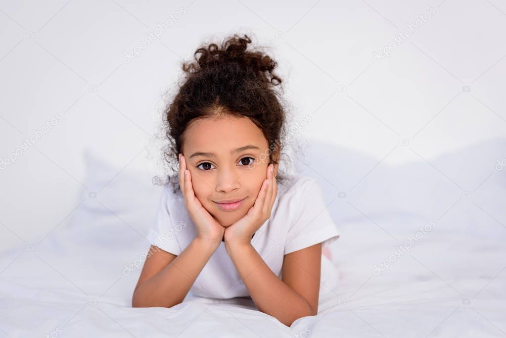 adorable african american kid resting chin on hands at home