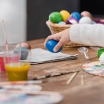 Imagen recortada de niño afroamericano sosteniendo huevo de Pascua pintado azul