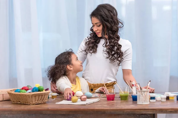 Africano Americano Madre Abrazando Hija Mesa Con Pascua Huevos — Foto de Stock