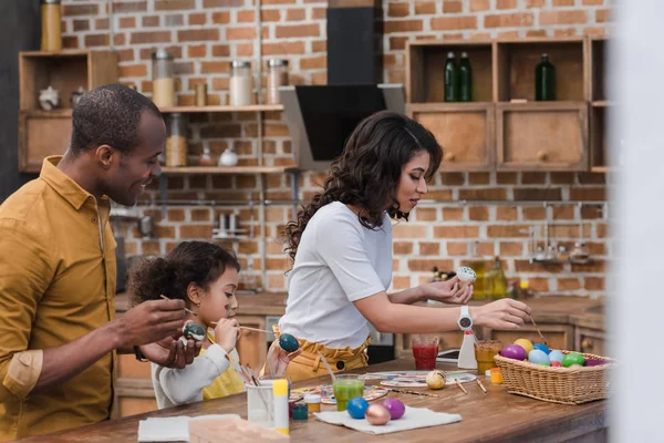Щасливі Афроамериканські Батьки Дочка Малюють Великодні Яйця Разом Кухні — стокове фото