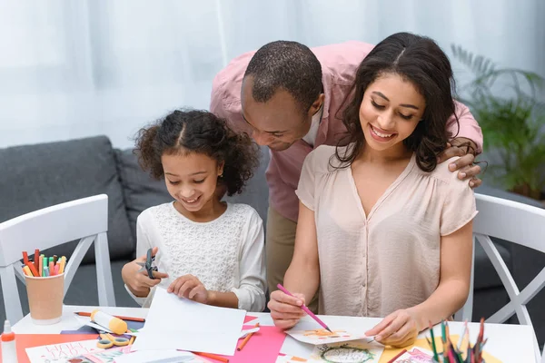 アフリカ系アメリカ人の両親と娘のグリーティング カードを作る  — 無料ストックフォト