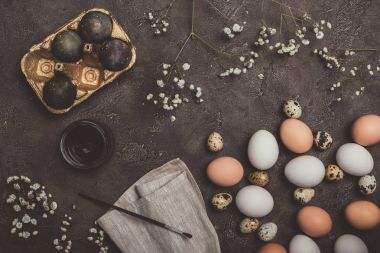 Altın tepsi, bıldırcın ve tavuk yumurta, boya ve fırça boyalı yumurta üstten görünüm üzerinde kumaş ve beton yüzey, Paskalya süsleri 