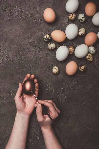 Обрезанный Вид Человека Живописи Золотые Пасхальные Яйца Перепела Куриные Яйца — Бесплатное стоковое фото