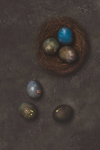 在混凝土桌上的巢上画复活节彩蛋的最高视图 — 免费的图库照片