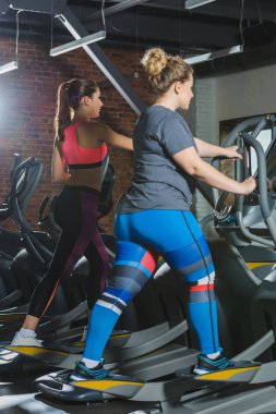 Sportif ve kilolu kadın spor salonunda koşu bandı üzerinde eğitim
