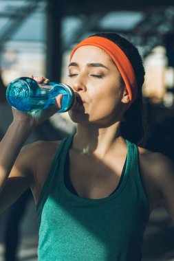 Sportif kadın içme suyu kapalı gözler ile spor salonunda
