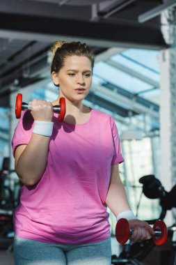 Spor salonunda halterli şişman kadın eğitimi.