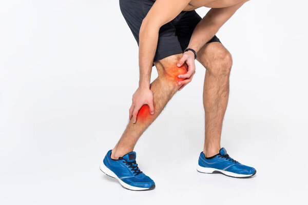 cropped shot of man with pain in leg on white