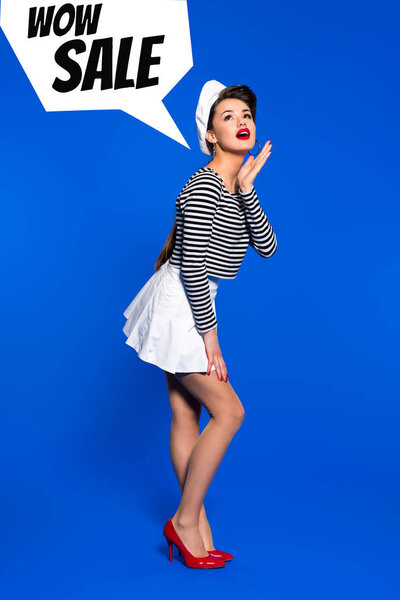 beautiful young woman in sailor shirt and wow sale speech bubble isolated on blue