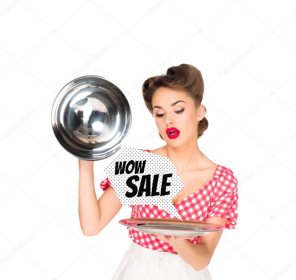 beautiful young woman in retro clothing with sale speech bubble on serving tray in hands isolated on white