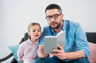 Baba ve kızı evde birlikte kitap okuma portre