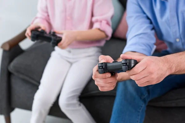 partial view of family playing video game together at home