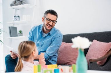 bir baba ile renkli oynarken kızı seyir seçici odak oturma odasında engeller