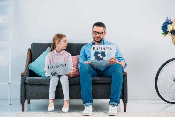 Padre Hija Leyendo Periódicos Mientras Descansan Sofá Casa —  Fotos de Stock