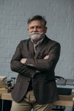çalışma alanı eğilerek gülümseyen kıdemli yazar