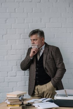 çalışma alanı duran tüvit kıyafetli yakışıklı kıdemli yazar