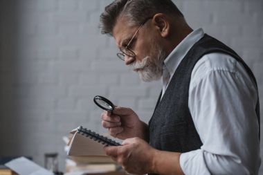 üst düzey yakışıklı büyüteç ile not defterinizdeki notlar okuma