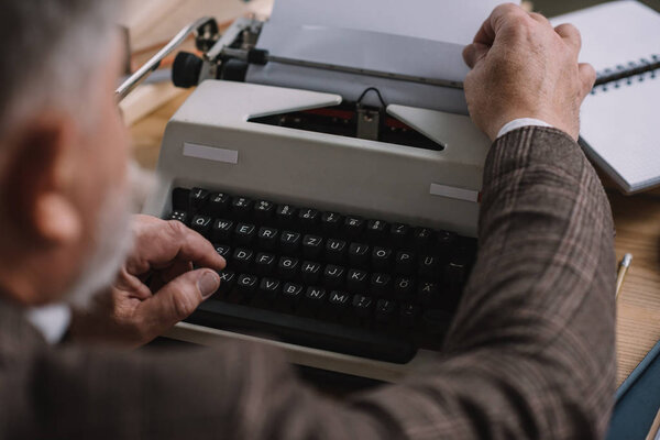 close-up shot of writer loading paper into typewriter