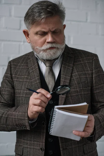 Hombre Mayor Traje Tweed Leyendo Notas Cuaderno Con Lupa — Foto de stock gratis