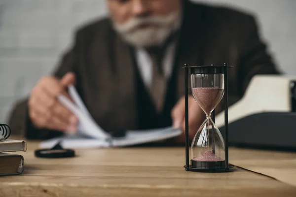 Senior Writer Working Hourglass Standing Foreground — Stock Photo, Image