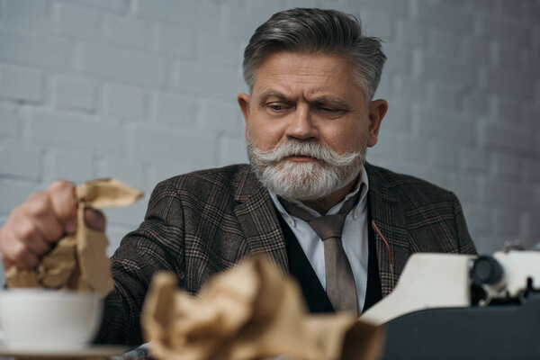 Депрессивная бумага старшего писателя крошка на рабочем месте
