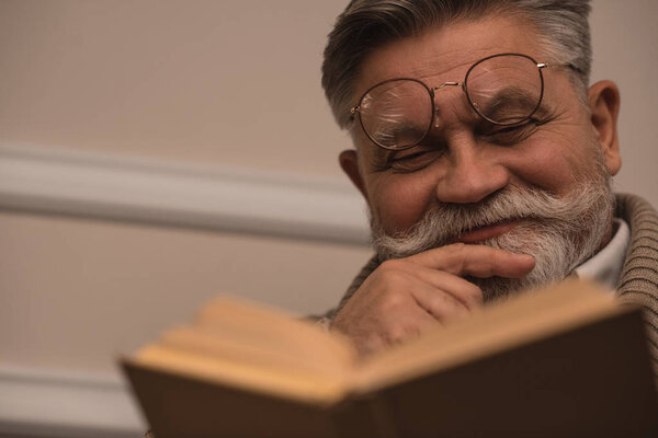 close-up portrait of senior man reading book