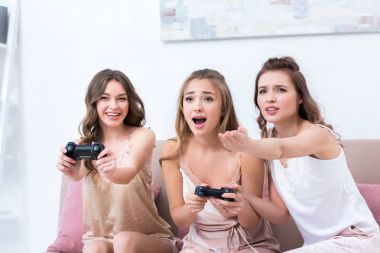 joystick ile birlikte evde oynarken pijama duygusal genç kadın