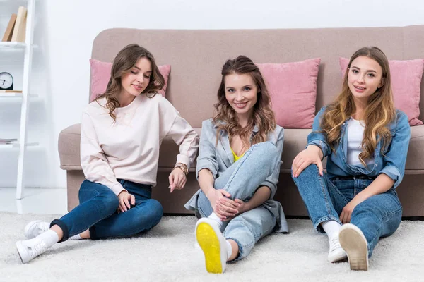 Beautiful Young Women Sitting Carpet Smiling Camera — Free Stock Photo