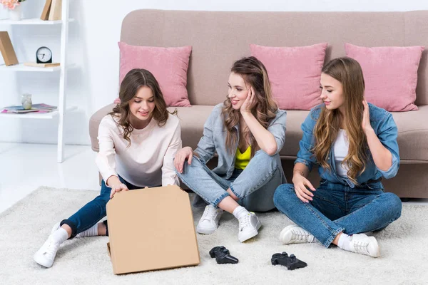 Belas Jovens Namoradas Sentadas Tapete Abrindo Caixa Pizza — Fotografia de Stock