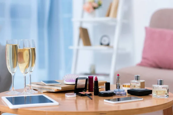 Close-up view of gadgets, glasses of champagne and various cosmetics on table — Stock Image Close View Gadgets Glasses Champagne Various Cosmetics Table Royalty Free Stock Images