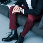 Partial view of businessman checking time while sitting on sofa