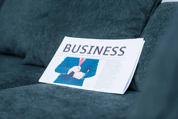 Close View Business Newspaper Grey Sofa — Free Stock Photo