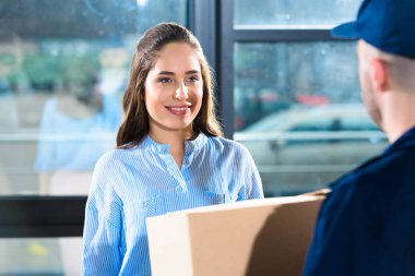 Delivery man giving woman package clipart