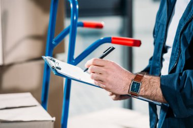 Close-up view of delivery man filling cargo declaration clipart