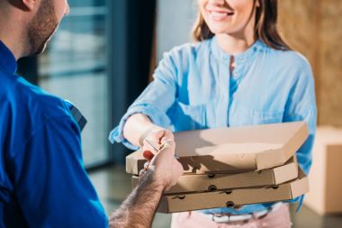 Pizza kutuları ve kurye için geçen kart yığını tutan kadın görmek