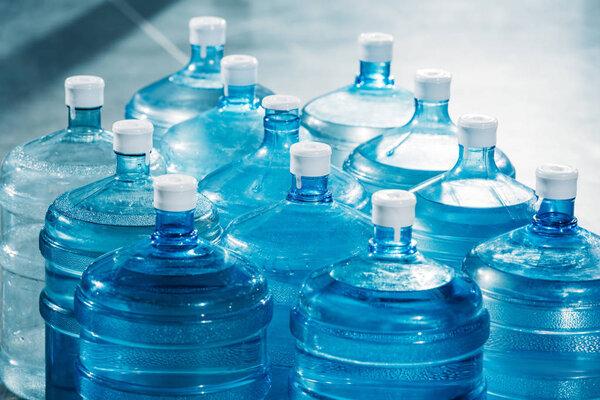 Пластиковые большие синие бутылки воды на полу
