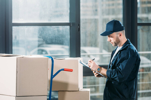 Courier checking cardboard boxes and cargo declaration