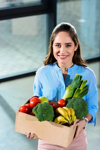 带新鲜水果和蔬菜的微笑的妇女拿着箱子 — 图库照片